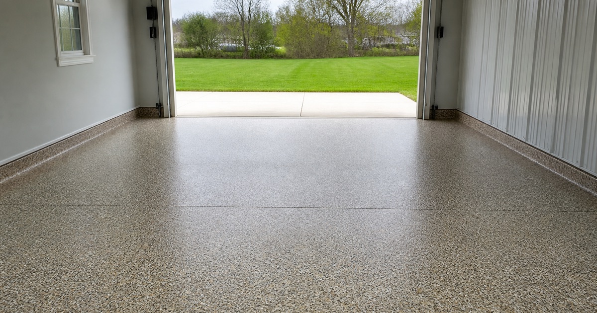 A grinder and extractor set up on a swept bare slab at the start of a Killeen garage floor job.